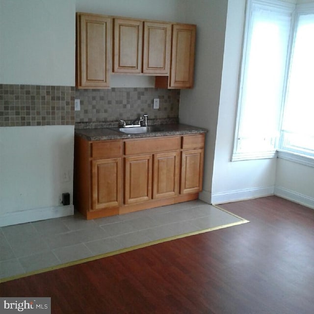 kitchen with tasteful backsplash, sink, and light hardwood / wood-style floors