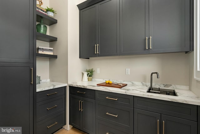 kitchen featuring light stone counters and sink