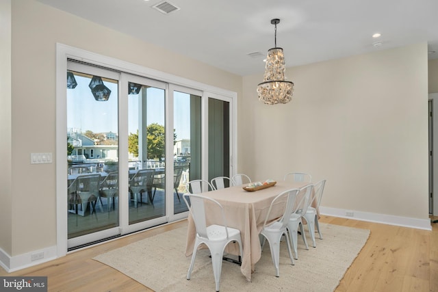 dining room featuring light hardwood / wood-style flooring and an inviting chandelier