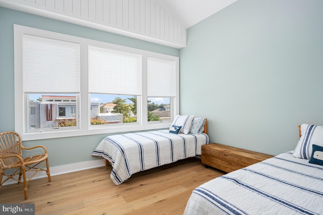 bedroom with light wood-type flooring and vaulted ceiling