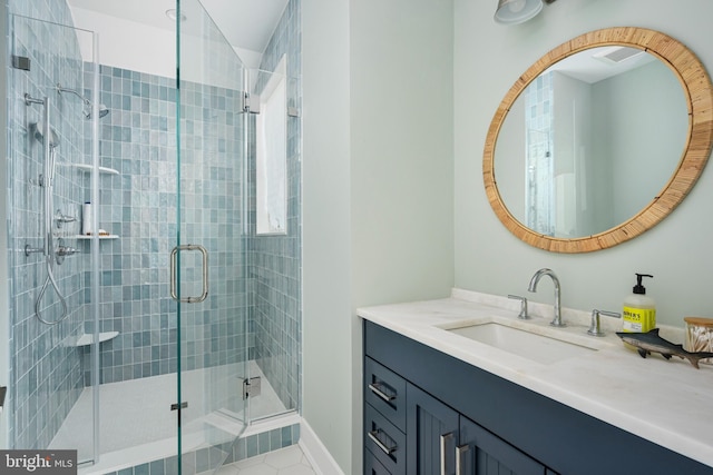 bathroom with tile patterned flooring, vanity, and walk in shower