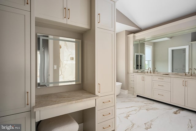 bathroom with vanity, vaulted ceiling, and plenty of natural light