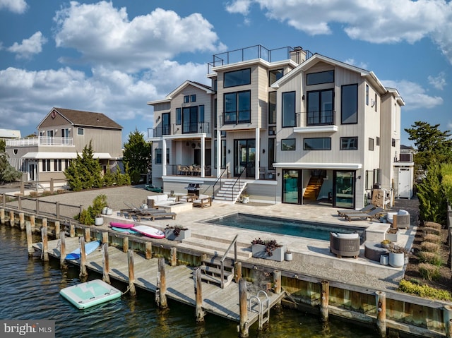 rear view of house featuring a water view and a patio