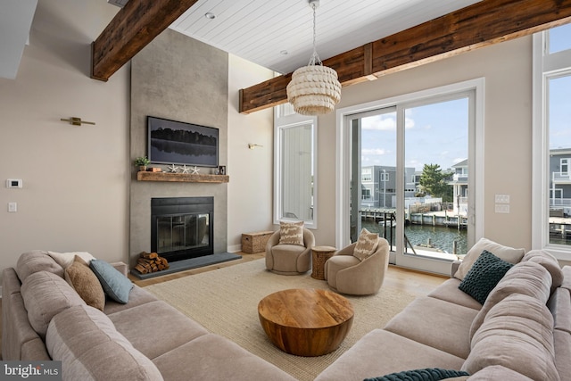 living room featuring beam ceiling, light wood-type flooring, and a fireplace