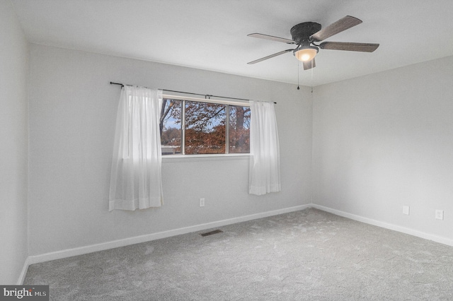 carpeted spare room featuring ceiling fan