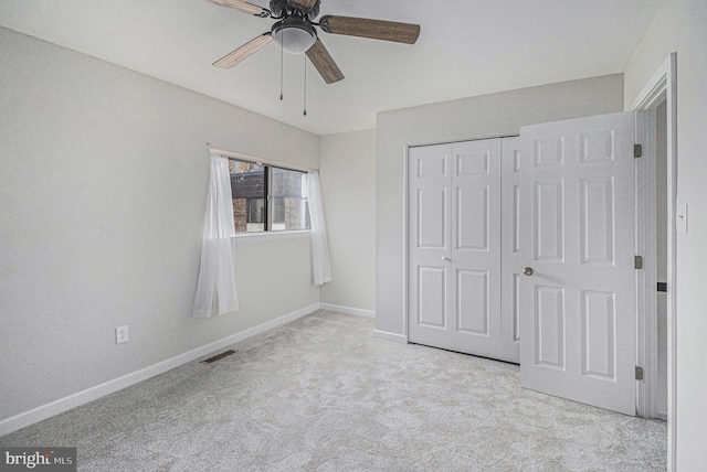 unfurnished bedroom featuring light carpet, a closet, and ceiling fan