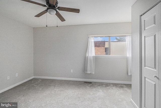 carpeted spare room featuring ceiling fan