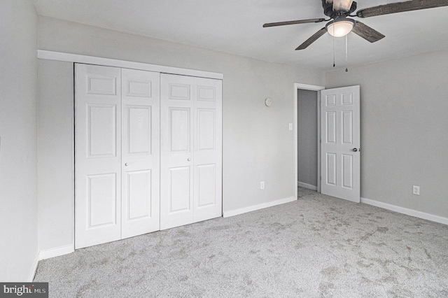 unfurnished bedroom with ceiling fan, light carpet, and a closet