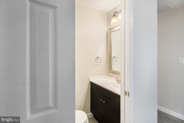 bathroom featuring vanity, toilet, and wood-type flooring