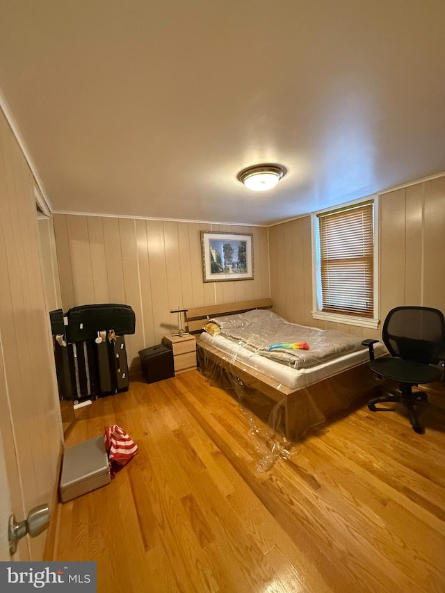 bedroom with light hardwood / wood-style floors, billiards, and wooden walls