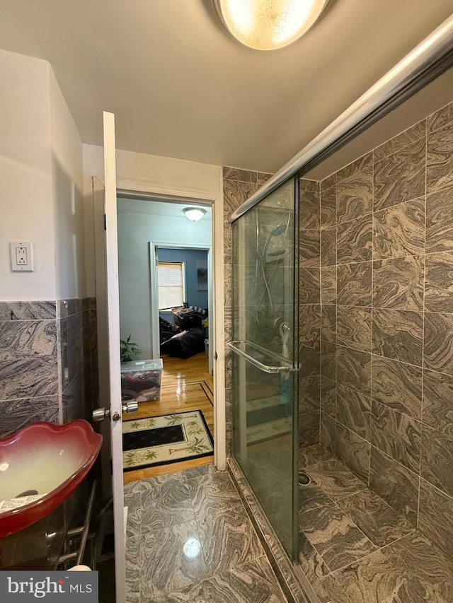 bathroom featuring wood-type flooring and an enclosed shower