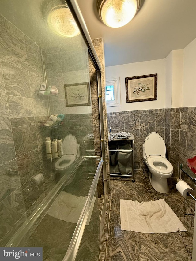 bathroom with tile patterned floors, toilet, tile walls, and an enclosed shower