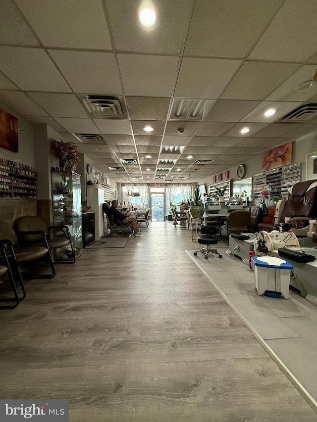 interior space featuring hardwood / wood-style flooring and a drop ceiling