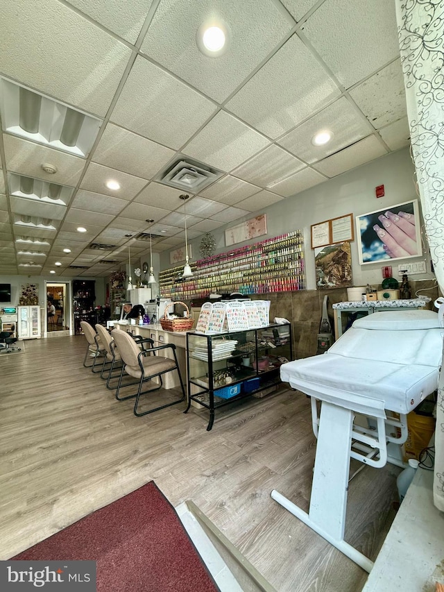 recreation room with hardwood / wood-style flooring and a drop ceiling