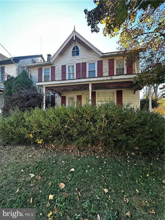 view of front of property featuring a porch and a front yard