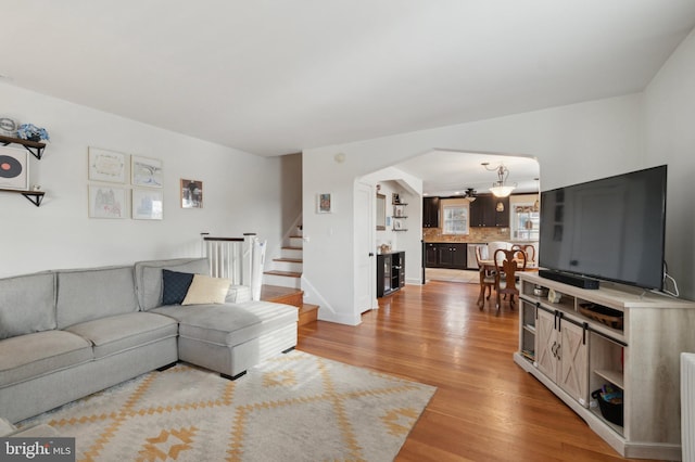 living room with ceiling fan and light hardwood / wood-style floors