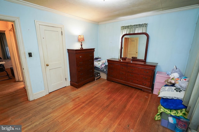 bedroom featuring crown molding and dark wood-type flooring