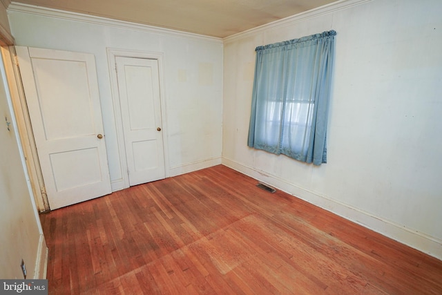 unfurnished bedroom with a closet, wood-type flooring, and ornamental molding