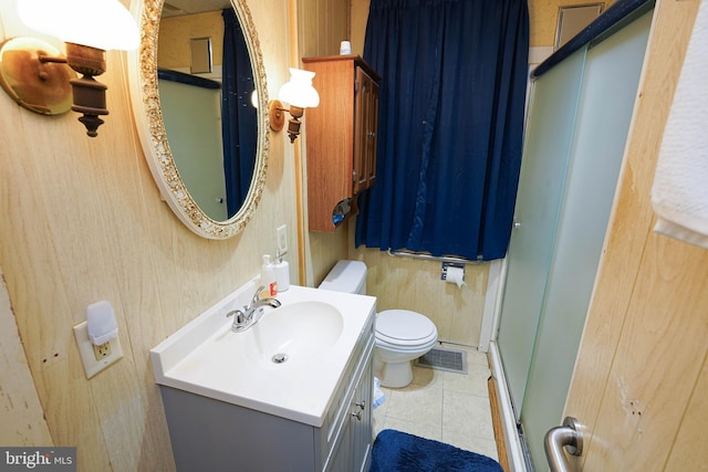 bathroom with tile patterned floors, vanity, an enclosed shower, and toilet