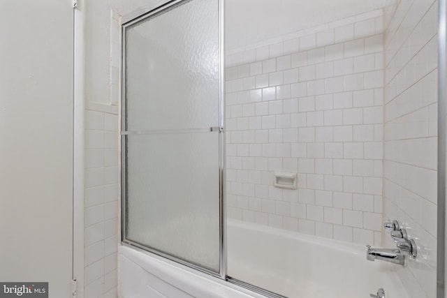 bathroom with shower / bath combination with glass door