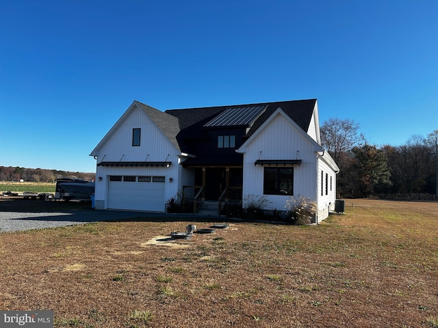 modern farmhouse featuring a front lawn, central AC unit, and a garage