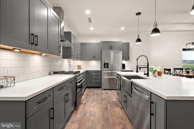 kitchen featuring gray cabinetry, sink, stainless steel appliances, and hardwood / wood-style flooring