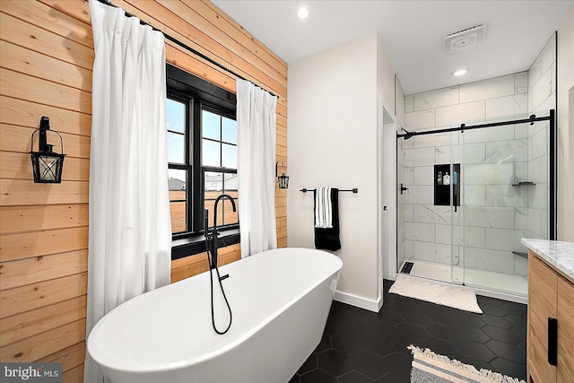 bathroom featuring tile patterned floors, wooden walls, vanity, and shower with separate bathtub