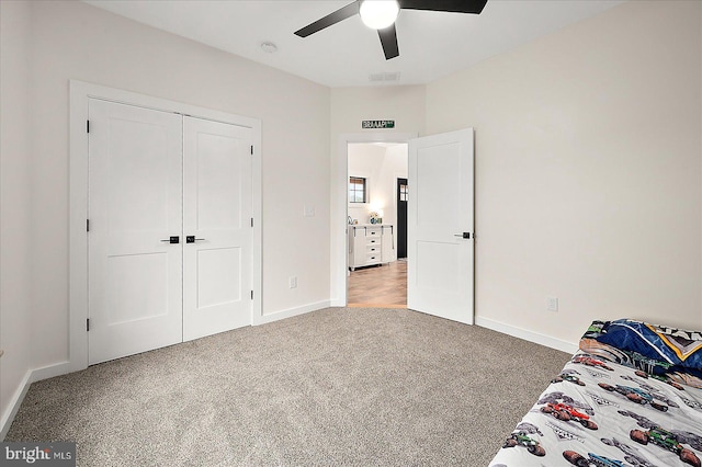 unfurnished bedroom with ceiling fan, a closet, and light colored carpet