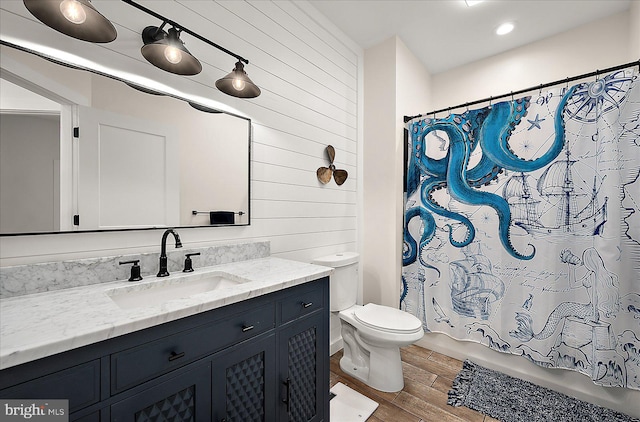 full bathroom with wood-type flooring, vanity, toilet, and shower / tub combo with curtain