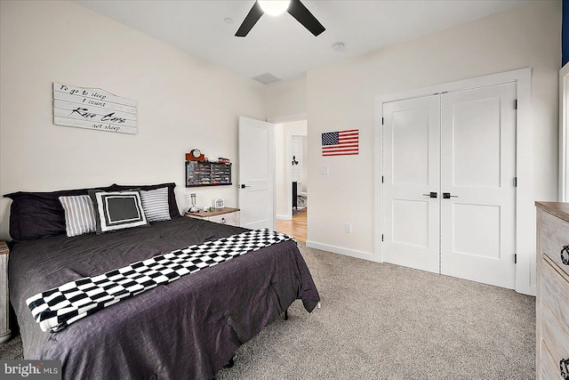 bedroom featuring ceiling fan, a closet, and light colored carpet