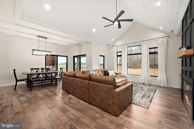 living room featuring dark hardwood / wood-style flooring, high vaulted ceiling, ceiling fan, and wood ceiling