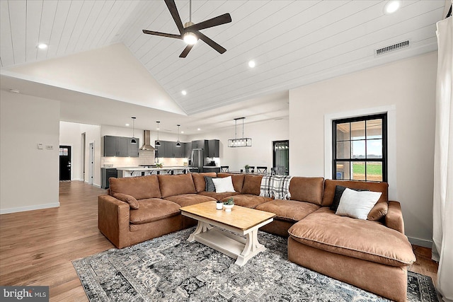 living room featuring light hardwood / wood-style flooring, high vaulted ceiling, wood ceiling, and ceiling fan with notable chandelier