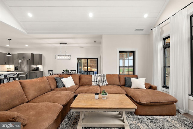 living room with wood-type flooring, lofted ceiling, and a chandelier