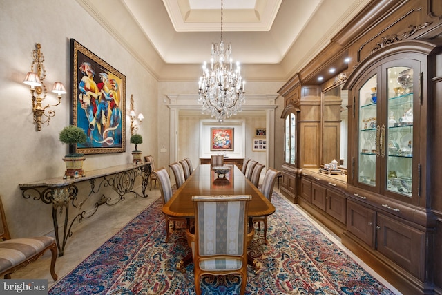 dining area featuring a tray ceiling, an inviting chandelier, and ornamental molding