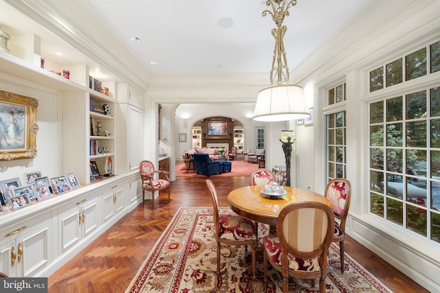 dining room with dark parquet floors, built in features, and crown molding