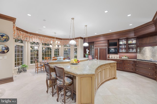 kitchen featuring pendant lighting, built in appliances, ornamental molding, tasteful backsplash, and a kitchen island