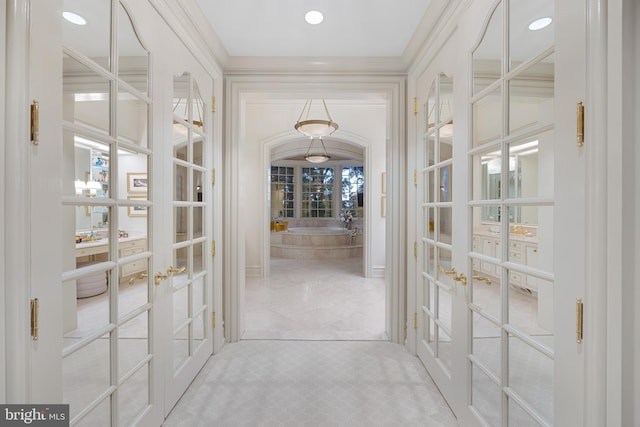 corridor featuring french doors and crown molding