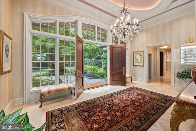 doorway to outside with a raised ceiling, an inviting chandelier, ornamental molding, and a high ceiling