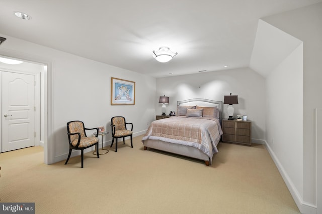 bedroom with light colored carpet and lofted ceiling