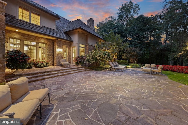 patio terrace at dusk featuring an outdoor living space