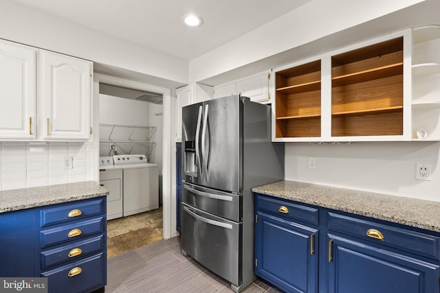 kitchen featuring white cabinets, washing machine and dryer, stainless steel fridge with ice dispenser, and blue cabinets