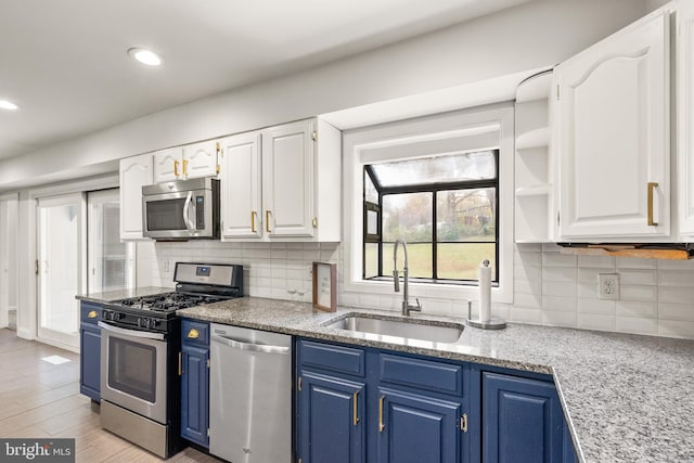 kitchen featuring white cabinets, stainless steel appliances, blue cabinets, and sink