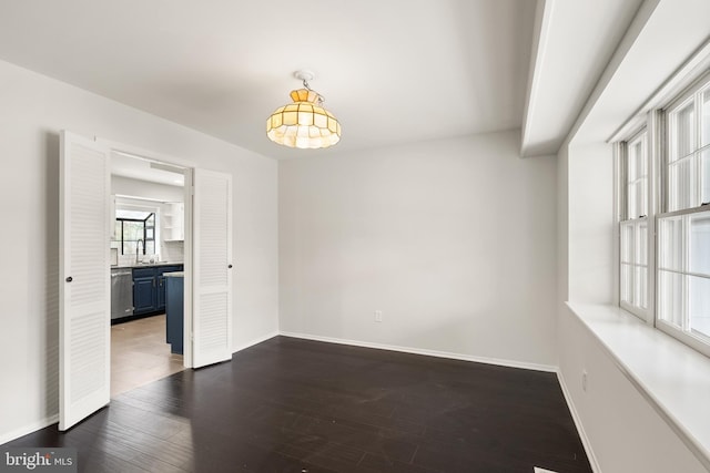 unfurnished room with dark hardwood / wood-style flooring and sink