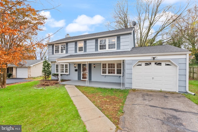 view of property with covered porch, a garage, and a front yard