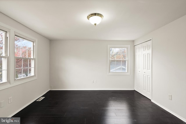 empty room featuring dark hardwood / wood-style floors and a wealth of natural light