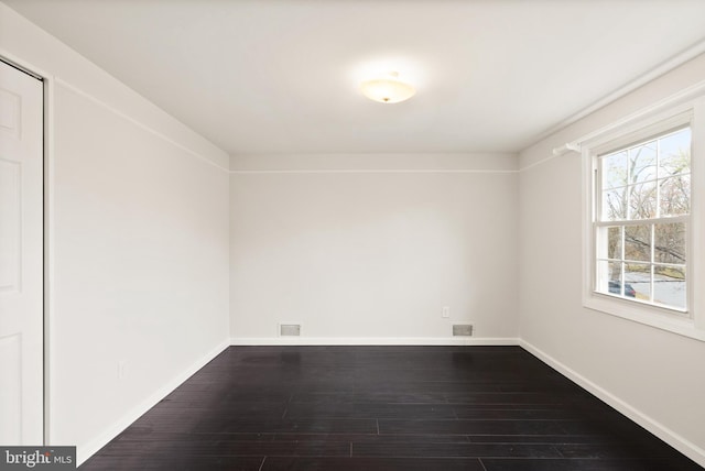 unfurnished room with dark wood-type flooring