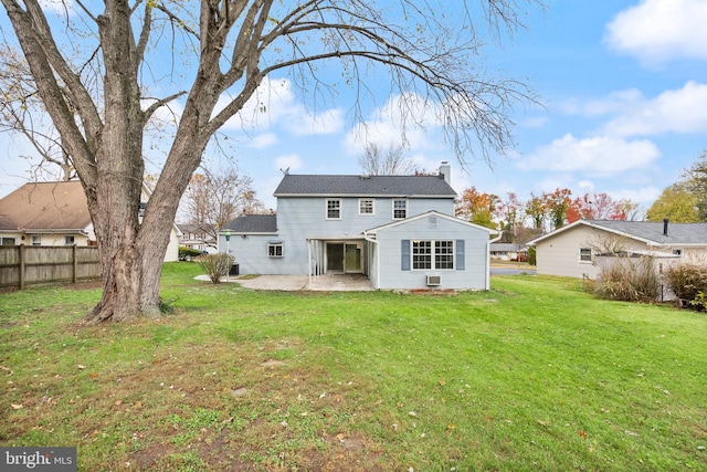 back of house with a yard and a patio