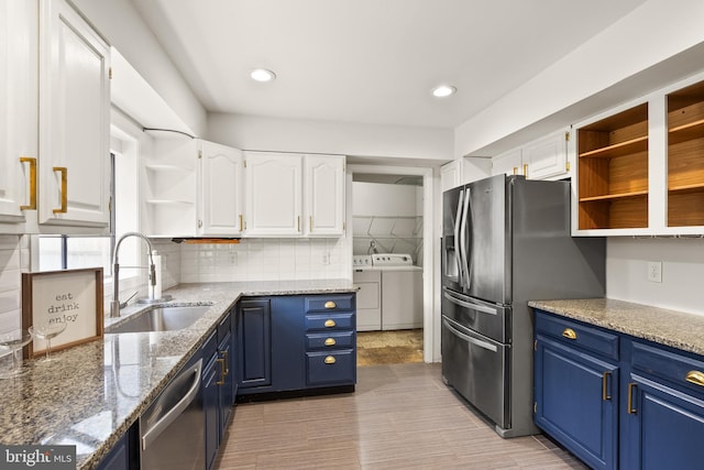 kitchen featuring white cabinetry, sink, light stone countertops, blue cabinets, and independent washer and dryer