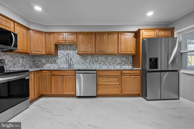 kitchen with light stone countertops, appliances with stainless steel finishes, backsplash, and sink