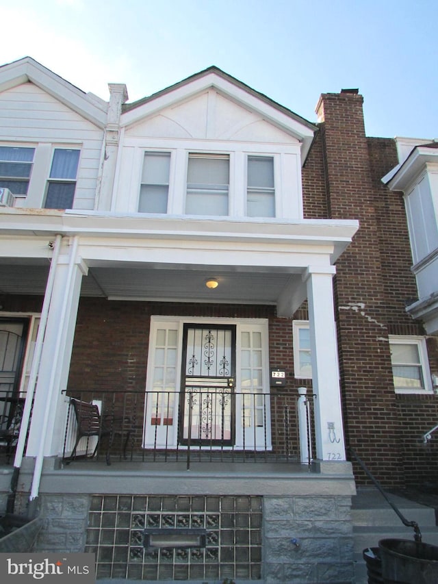 exterior space featuring covered porch and brick siding